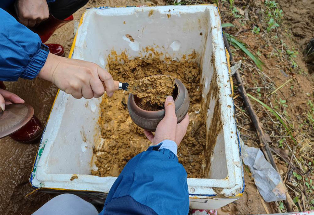 乘客家屬使用陶罐帶現場泥土回家